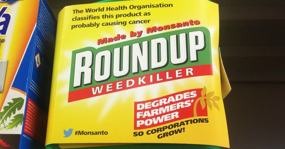 Au Royaume-Uni, des activistes ont ajouté des étiquettes sur les bidons de Roundup : "l'OMS a classifié ce produit comme probablement cancéreux." © Global Justice Now